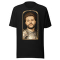 Black t-shirt featuring an exclusive pencil-sketch and engraving portrait of The Weeknd. The design depicts the artist as a medieval knight wearing detailed plate armor. The artwork is encased in an ornate gold arched border inspired by 14th-century illuminated manuscripts.